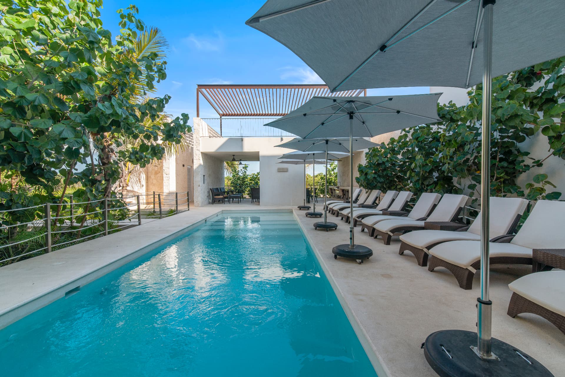 Pool and shaded loungers at a PPIM Akumal condo community
