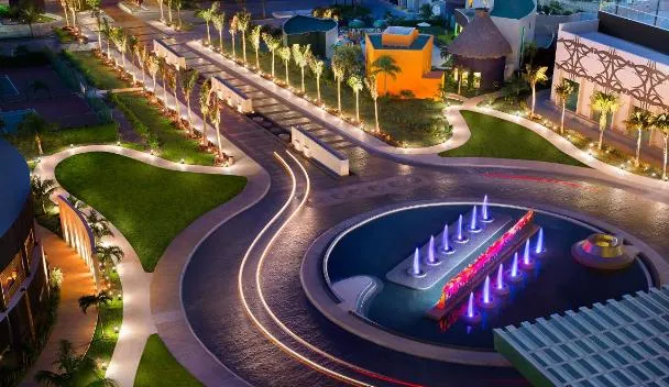 Aerial evening view of an all-inclusive resort in the Riviera Maya with illuminated pools and tropical grounds