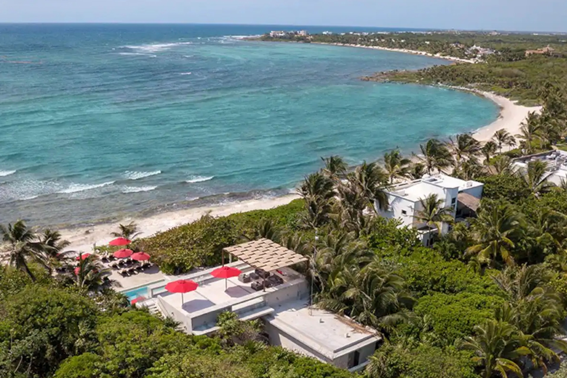 Jungle Fish restaurant with turquoise Caribbean water and white sand beach in the background