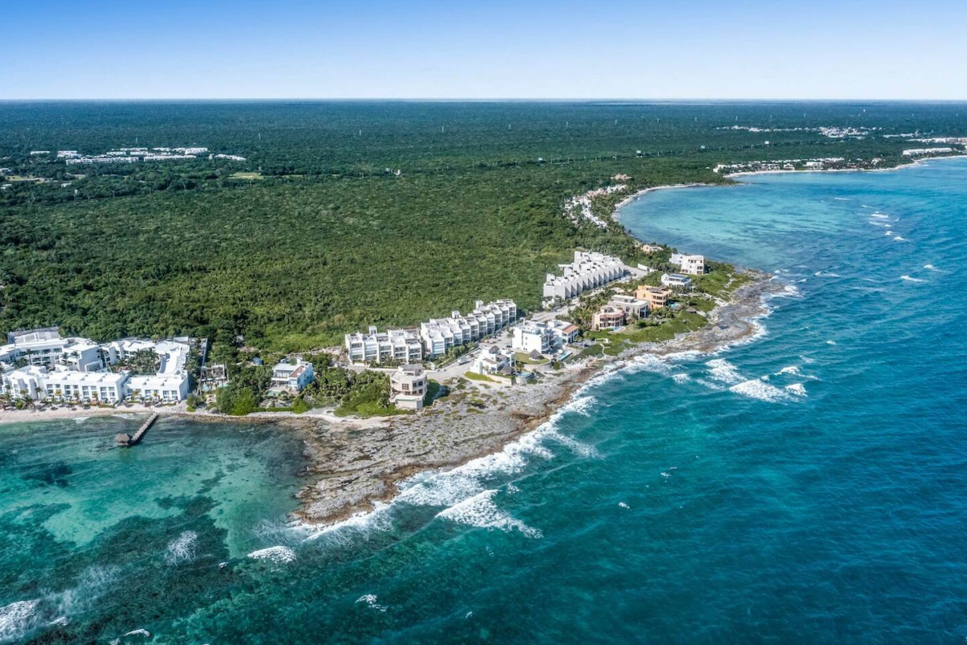 Condo community in Akumal with rooftop pools and palm trees near the Caribbean coast