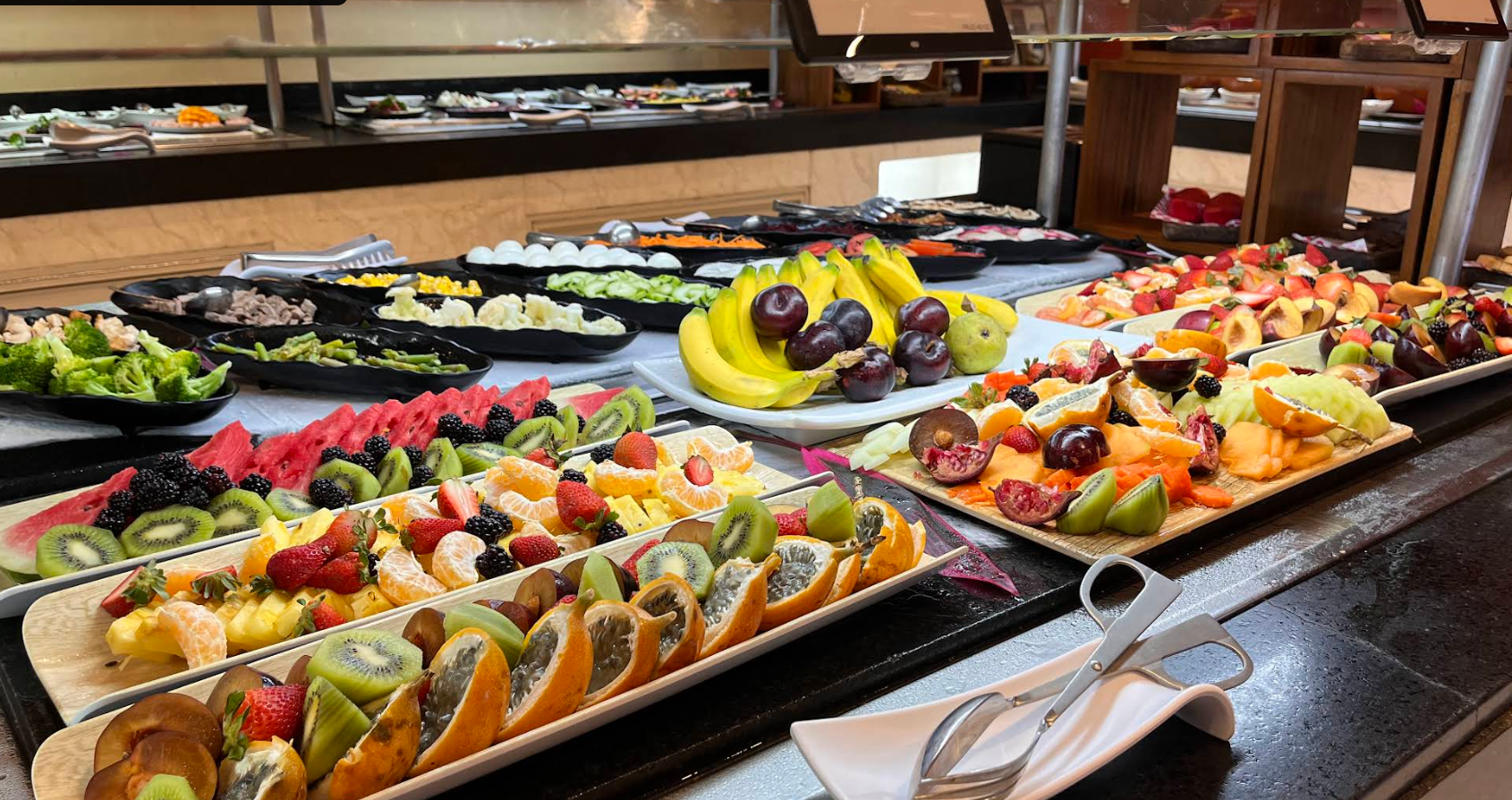 Fresh fruit and buffet spread at Yal-Ku Restaurant Buffet with tropical fruits, salads, and breakfast selections