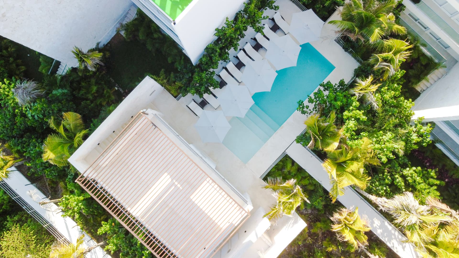 Aerial view of a Santamar by TAO condo building, pool terrace and palm gardens