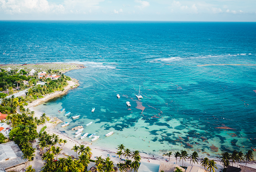 Akumal Bay seen from above with turquoise water and the village shoreline