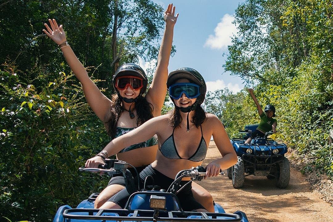 Riders on ATVs speeding along a sandy jungle trail near Akumal