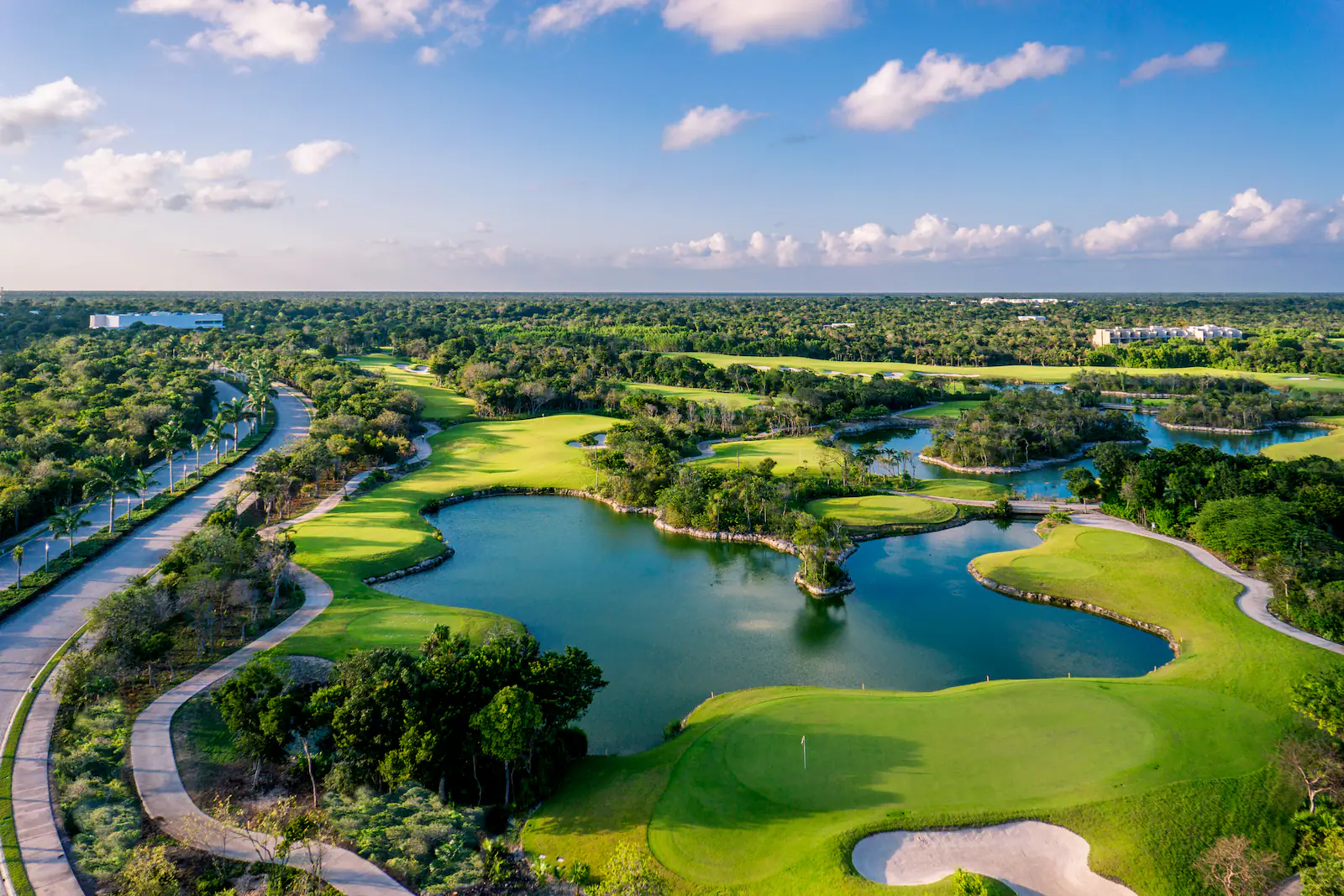 Aerial view of the golf course, lagoons and jungle inside Tulum Country Club near Akumal