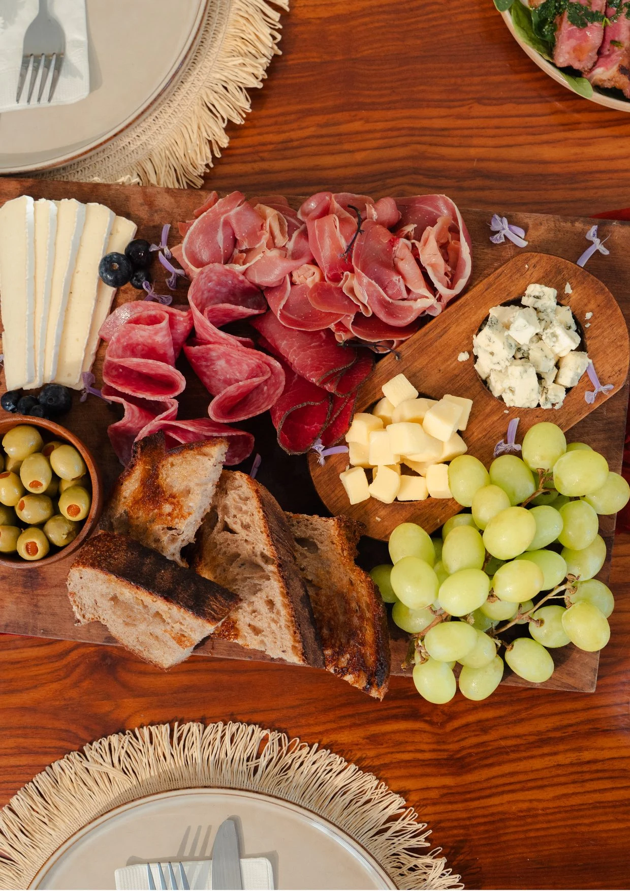 Mesa para compartir con quesos, fruta y pan
