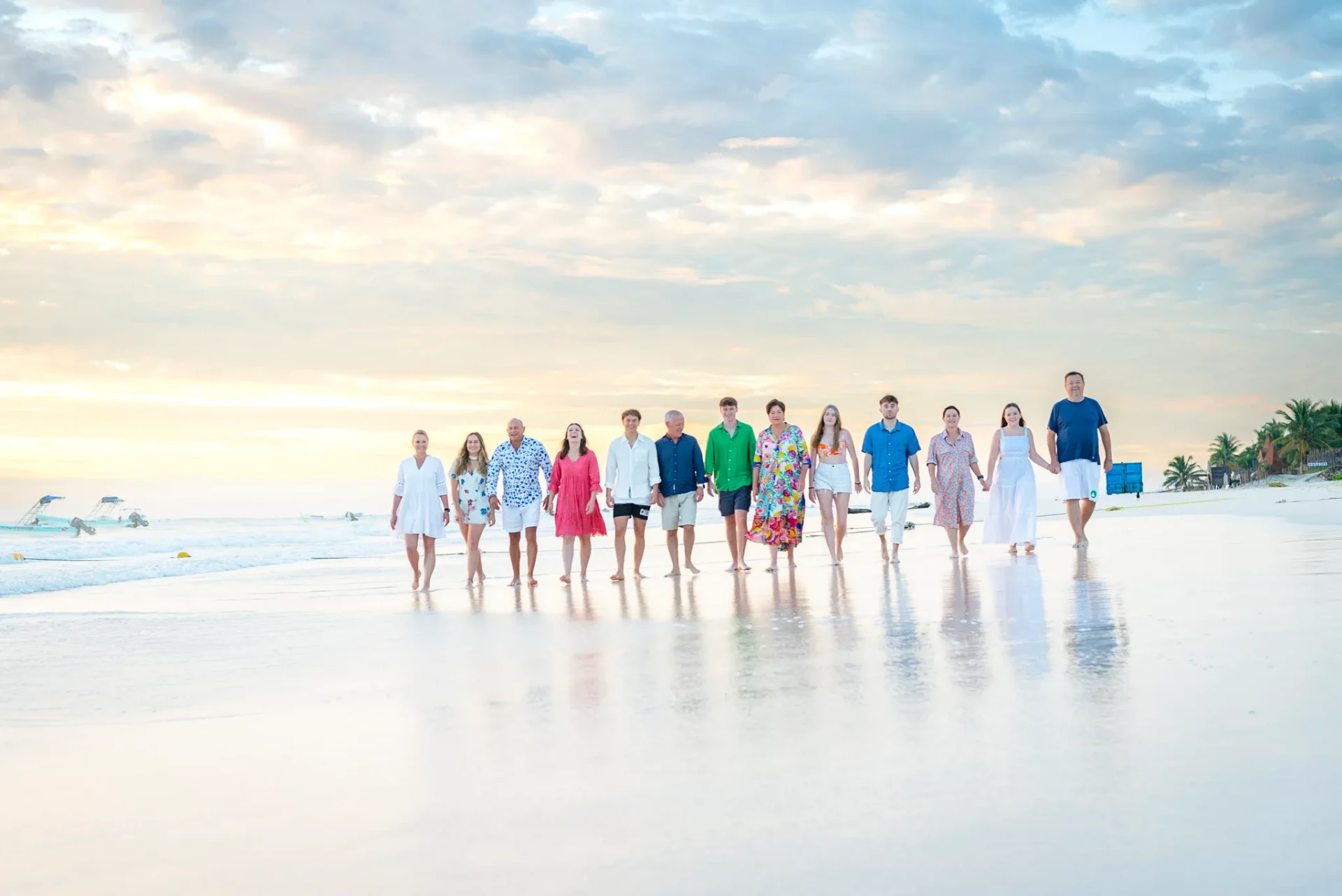 Family walking together at sunset on a white-sand Riviera Maya beach during a professional vacation photography session